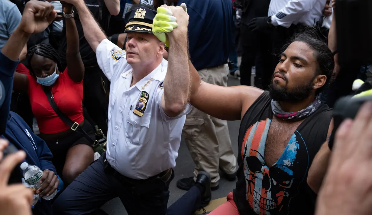 Kepala Departemen Kepolisian Kota New York, Terence Monahan berlutut bersama pengunjuk rasa dalam aksi protes kematian George Floyd, Senin (1/6/2020). Unjuk rasa besar melanda Amerika atas kematian pria kulit hitam yang tak bisa bernafas karena tercekik lutut polisi saat ditangkap. (AP/Craig Ruttle)