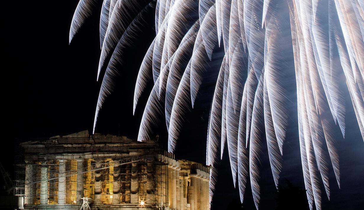 Kembang api meledak di atas Kuil kuno Parthenon dari bukit Acropolis pada malam pergantian tahun di Athena, Yunani, Minggu (1/1). Sebagian besar negara merayakan datangnya tahun baru 2017 dengan pesta kembang api. (REUTERS/Alkis Konstantinidis)