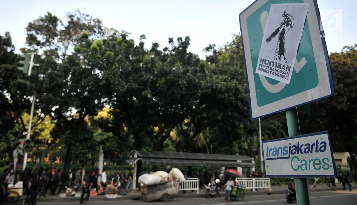 Poster tuntutan buruh terlihat di Jalan Merdeka Barat, Jakarta, Selasa (1/5). Aksi May Day di Jakarta meninggalkan jejak vandalisme yang dibuat kaum pekerja itu. (Merdeka.com/ Iqbal S. Nugroho)