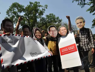 Para aktivis menggunakan topeng sejumlah kepala daerah saat melakukan aksi di depan Istana Merdeka, (16/8/14). (Liputan6.com/Miftahul Hayat)