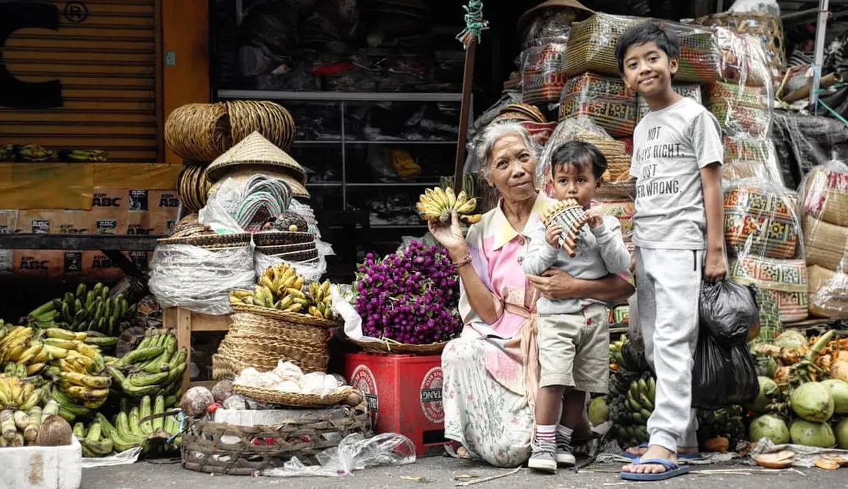 Anak-anak dari Widi Mulia dan Dwi Sasono tampak menyempatkan diri untuk berfoto dengan salah satu penjual di pasar Sukawati. Tak hanya itu, mereka mendapatkan pisang dari penjual yang bernama Ibu Ayu. (Foto: instagram.com/widimulia)