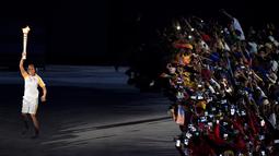 Mantan atlet Brasil, Hortencia Marcari, membawa obor api olimpiade memasuki stadion saat Pembukaan Olimpiade Rio 2016 di Stadion Maracana, Rio de Janeiro, Brasil, (5/8/2016). (AFP/William West)