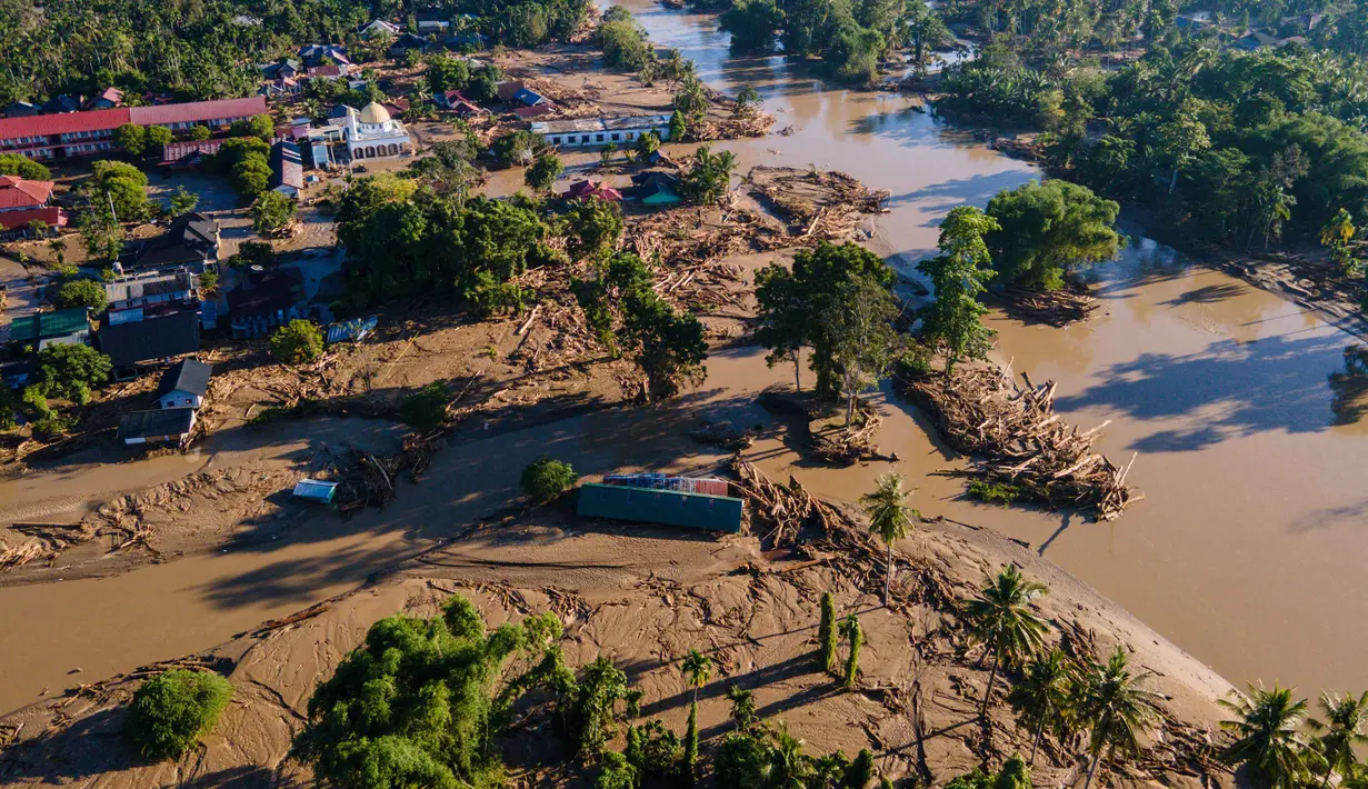 Sejumlah rumah rusak berat dan tertimbun lumpur serta sampah kayu akibat banjir bandang. Tampak foto udara menunjukkan kerusakan akibat banjir di Meureudu, Kabupaten Pidie Jaya, Provinsi Aceh, pada 30 November 2025. (CHAIDEER MAHYUDDIN/AFP)