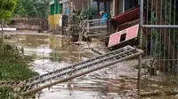 Banjir yang melanda Bojongkukur, Kecamatan Gunungputri, Kabupaten Bogor berangsur-angsur mulai surut dan menyisakan lumpur serta genangan di jalan dan permukiman warga, Minggu (25/10/2020). (Liputan6.com/Achmad Sudarno)