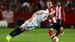 1. Bek Sevilla, Grzegorz Krychowiak, berebut bola dengan striker Athletic Bilbao, Iker Muniain, pada laga Liga Europa di Stadion Ramon Sanchez Pizjuan, Spanyol, Kamis (14/4/2016). Sevilla lolos ke semifinal melalui adu penalti. (Reuters/Marcelo Del Pozo)