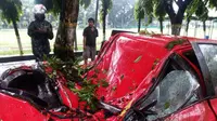 Salah satu mobil yang tertimpa pohon tumbang akibat hujan deras dan angin kencang di Kota Makassar, Sulawesi Selatan. (Liputan6.com/Eka Hakim)