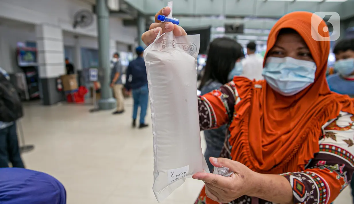 Calon penumpang kereta api menutup kantong berisi nafasnya yang kemudian dites COVID-19 dengan GeNose C19 di Stasiun Pasar Senen, Jakarta, Jumat (5/2/2021). PT Kereta Api Indonesia memberlakukan calon penumpang menjalani GeNose C19 untuk tes COVID-19. (Liputan6.com/Faizal Fanani)