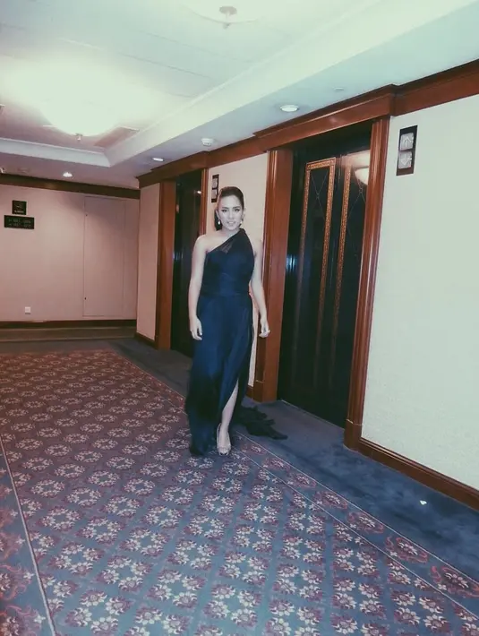 Masih dengan dress hitamnya. Dan kali ini, Angel mengenakan gaun yang panjangnya menjuntai hingga ke lantai. Ia hanya menambahkan anting sebagai aksesoris pemanis dalam penampilannya. (Instagram/angelpieters)