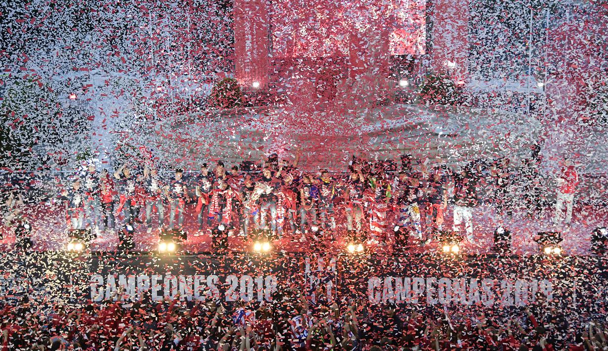 Warga Madrid tumpah ke jalan saat menyambut para pemain Atletico Madrid merayakan gelar Liga Europa di Madrid, Jumat (18/5/2018). Kota Madrid menjadi merah saat perayaan gelar juara Atletico. (AFP/Javier Soriano)