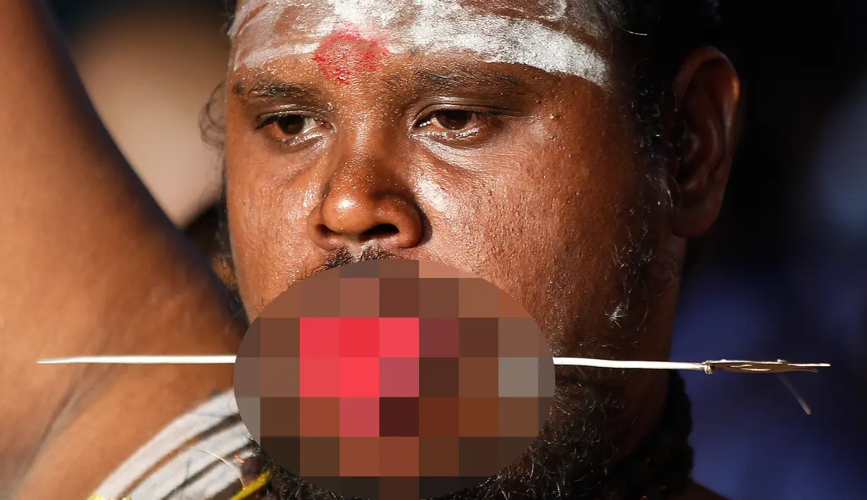 Seorang umat Hindu menusukkan besi ke pipinya saat Festival Thaipusam di Batu Caves, Kuala Lumpur, Malaysia, Rabu (31/1). Thaipusam adalah prosesi tahunan umat Hindu. (AP Photo/Sadiq Asyraf)