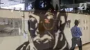 Pengamanan dalam DPR  melihat karya lukis dan karya foto pada pameran 150 Tahun Mahatma Gandhi di kompleks Parlemen, Senayan, Jakarta, Jumat (2/10/2020). Pameran ini kerjasama Kedubes India dan DPR mengambil tema "kebenaran, anti kekerasan dan Satyagraha". (Liputan6.com/Johan Tallo)