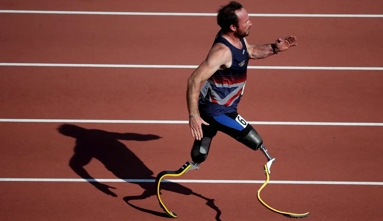 Luke Sinnott saat berlari mengenakan kaki palsunya dalam kompetisi IT2 100m Heat 2 selama Invictus Games 2017 di Stadion York Lions, Toronto, Kanada (24/9). Luke Sinnott lahir pada 9 September 1980. (Gregory Shamus/Getty Images/AFP)