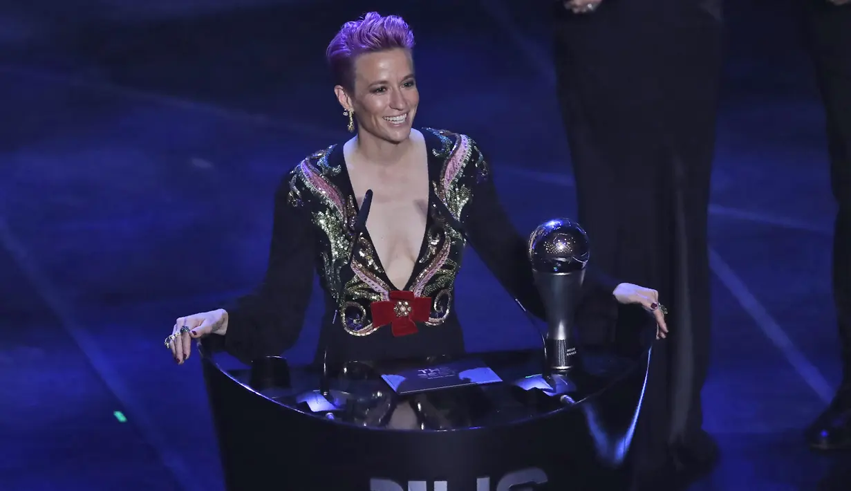 Penyerang Amerika Serikat, Megan Rapinoe memberi sambutan usai menerima penghargaan pemain Wanita FIFA Terbaik 2019 di teater La Scala Milan, Italia utara (23/9/2019). Di acara tersebut Rapinoe tampil seksi mengenakan gaun hitam dengan belahan dada rendah. (AP Photo/Antonio Calanni)