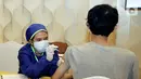 Petugas medis memvaksin warga di Menara Mandiri, Jakarta, Senin (26/7/2021). Vaksinasi kolaborasi yang menyasar sebanyak 15.000 keluarga pegawai, nasabah dan masyarakat umum, termasuk anak berusia ≥12 tahun, digelar pada 21 Juli - 3 Agustus 2021. (Liputan6.com/Pool/Mandiri)