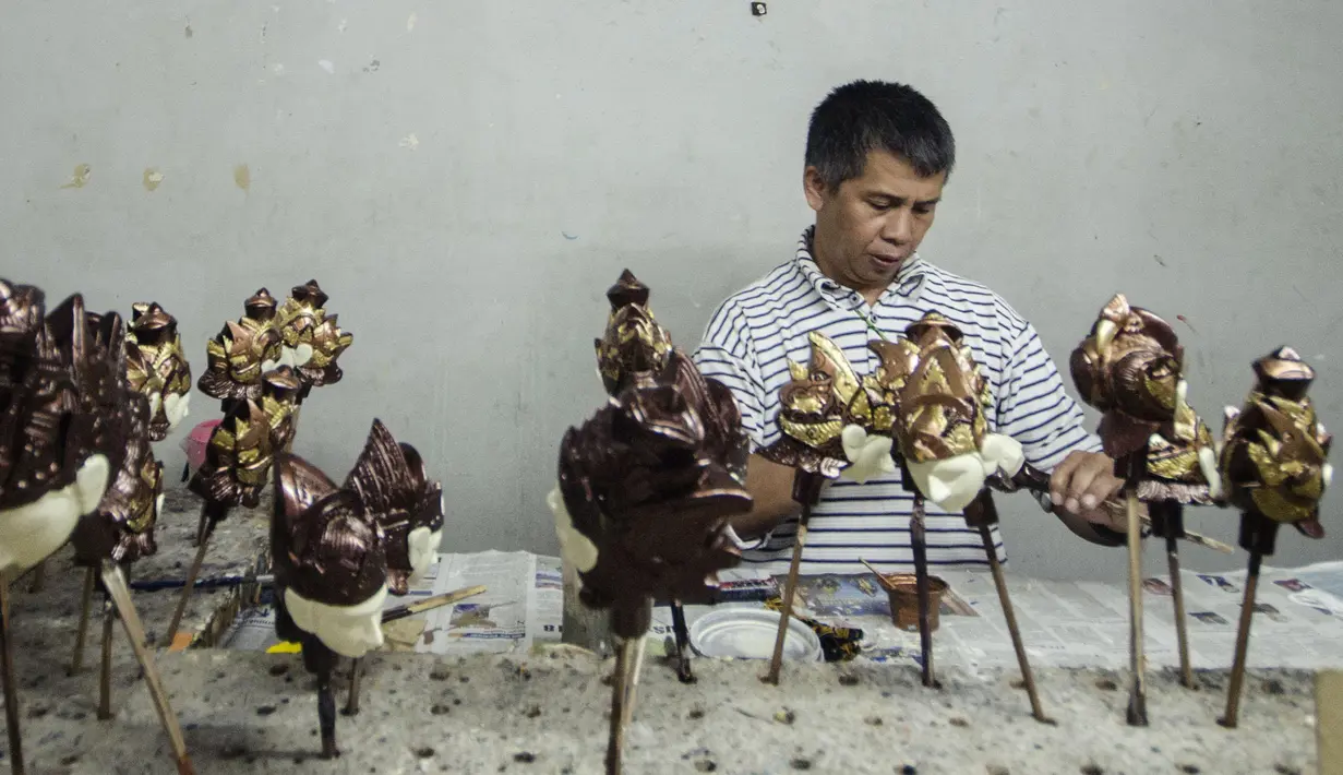 Seorang perajin mewarnai wayang kayu khas Sunda atau wayang golek di galeri kerajinan tangan Cupumanik di Bandung, 17 Februari 2020. Galeri kerajinan tangan Cupumanik memproduksi berbagai wayang golek untuk digunakan dalam pertunjukan wayang khas Sunda. (Xinhua/Septianjar)