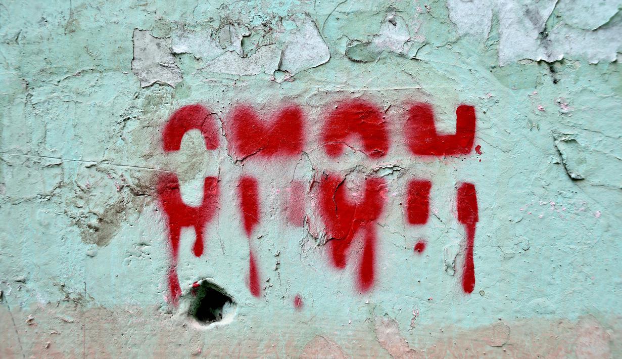 Grafiti bertuliskan "Polisi anti huru hara" di dinding di Minsk (25/8/2020). Belarusia sedang menghadapi krisis politik yang tidak terduga dengan demonstran membanjiri jalan-jalan selama lebih dari dua minggu menuntut pengunduran diri pemimpin otoriter  Alexander Lukashenko. (AFP/Sergei Gapon)