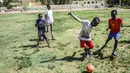 Seorang anak menggiring bola saat berman sepak bola di Khartoum (23/4). Khartoum yang merupakan pusat politik, kebudayaan, dan perdagangan. (AFP Photo/Ozan Kose)