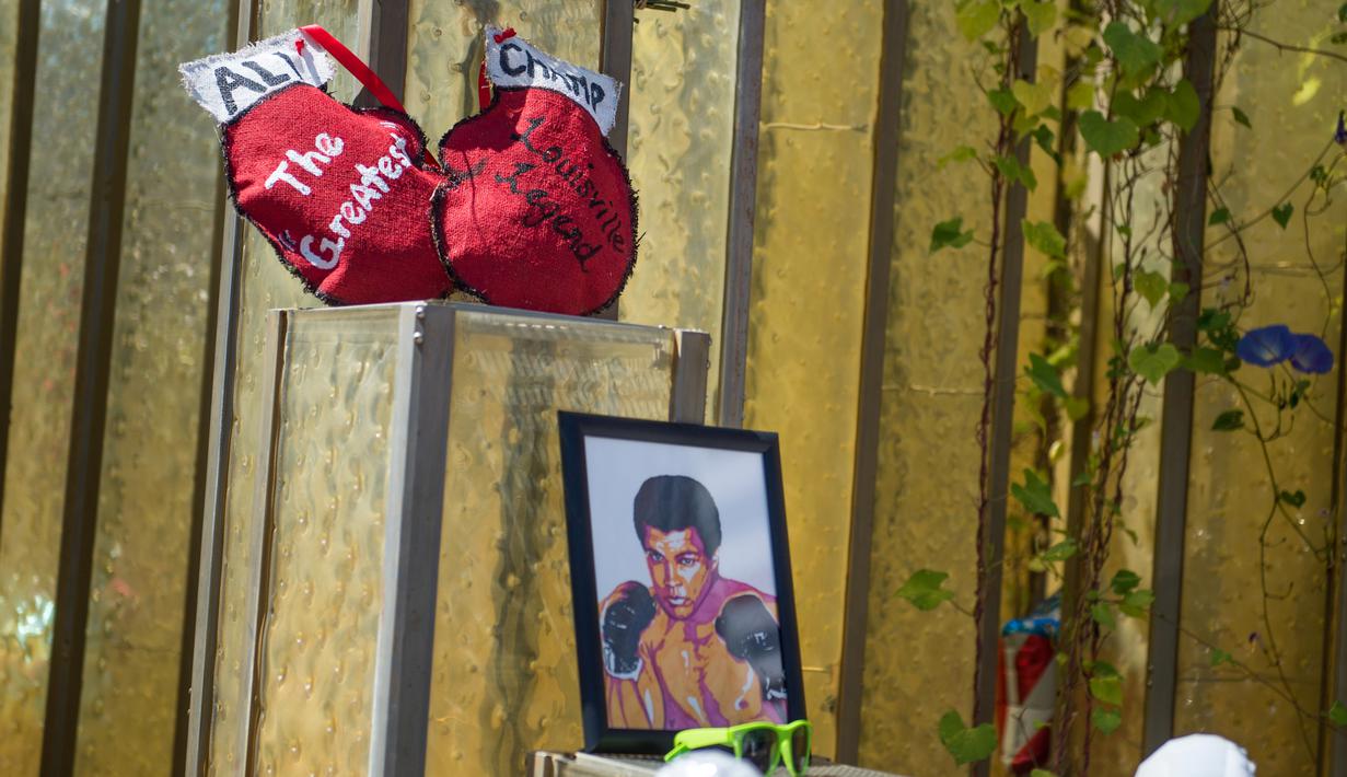 Beberapa barang yang diletakkan oleh para penggemar di luar gedung Muhammad Ali Center sebagai penghormatan kepada sang legenda di Louisville, Kentucky, (8/6/2016). (AFP/Michael B. Thomas)
