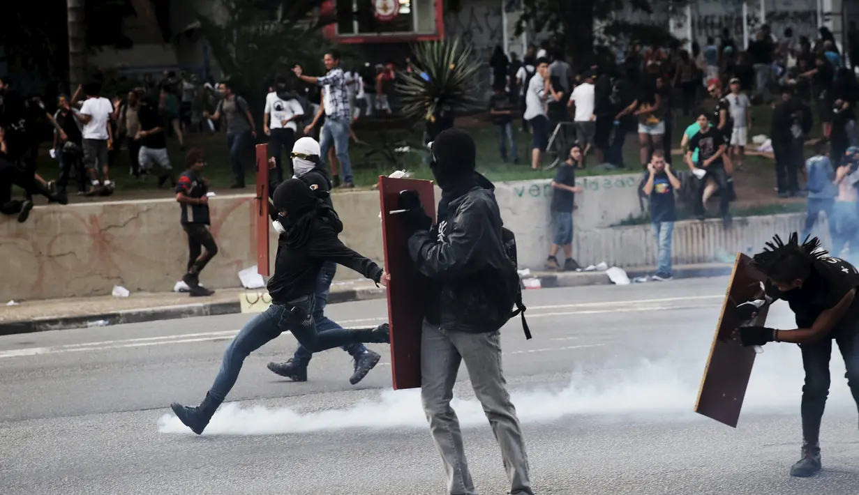 Seorang demonstran menendang gas air mata yang ditembakkan Polisi Anti Huru hara, Brasil, Jumat (8/1/2016). Pengunjuk rasa protes terhadap kenaikan tarif untuk bus kota di Sao Paulo. (Reuters/Nacho Doce)