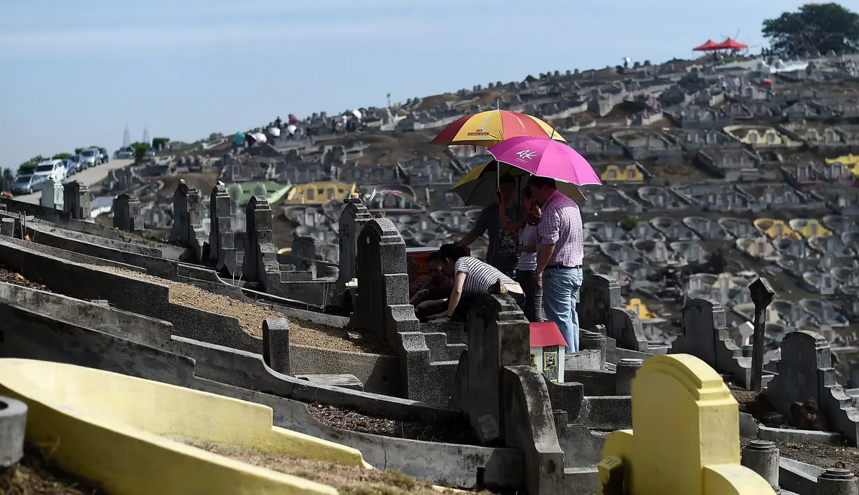 Keluarga etnis China Malaysia mengunjungi makam leluhur pada festival tahunan Qingming (Cheng Beng) di Kuala Lumpur, Minggu (3/4). Festival ini merupakan hari ziarah kubur ditandai dengan mengunjungi dan membersihkan kuburan leluhur (MANAN Vatsyayana/AFP)