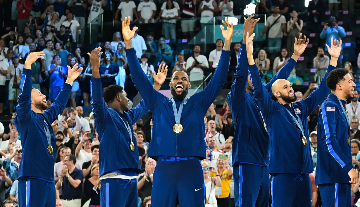 LeBron James dan sejumlah pebasket Amerika Serikat melakukan selebrasi setelah berhasil mendapatkan medali emas Olimpiade Paris 2024 setelah mengalahkan Prancis dengan skor 98-87 pada pertandingan final yang berlangsung di Bercy Arena, Paris, Prancis, Minggu (11/08/2024) dini hari WIB. (AFP/Damien Meyer)