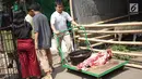 Seorang panitia membawa daging hewan kurban pada Idul Adha 1440 H di halaman Masjid Sunda Kelapa, Jakarta, Minggu (11/8/2019). Setiap tahun, Masjid Sunda Kelapa rutin melakukan penyembelihan hewan kurban yang berasal dari masyarakat. (Liputan6.com/Immanuel Antonius)