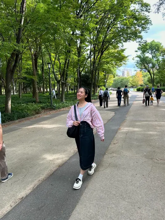 Penampilannya dilengkapi dengan sneakers warna putih serta shoulder bag hitam yang menjadikan pesonanya begitu menawan bak anak kuliahan.