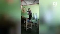 Video kocak menampilkan pria bersarung tengah memarkan jurus handalannya, lalu nyungsep dari atas kursi.