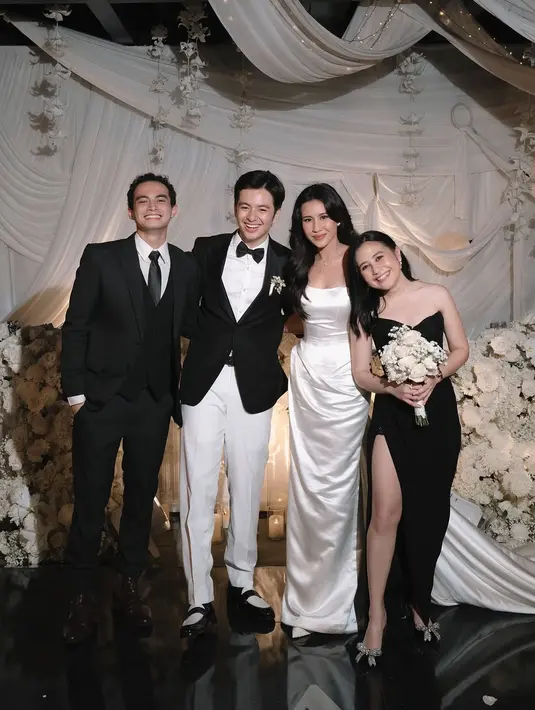 Untuk aksesori, Prilly memilih clutch silver bertekstur metalik yang memberikan kontras subtle namun tetap harmonis. Sepasang heels dengan aksen pita kristal melengkapi penampilannya, menambah kilauan ekstra yang tidak berlebihan.