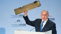 PM Israel Benjamin Netanyahu menunjukkan benda yang diduga potongan pesawat tak berawak Iran yang ditembak jatuh di wilayah udara Israel saat pidato dalam Konferensi Keamanan Munich (18/2). (AFP/ MSC Munich Security Conference / Lennart Preiss)