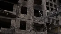 Seorang petugas pemadam kebakaran Ukraina bekerja di sebuah gedung apartemen setelah terkena tembakan artileri di Kyiv, Ukraina (14/3/2022). (AP Photo/Felipe Dana)