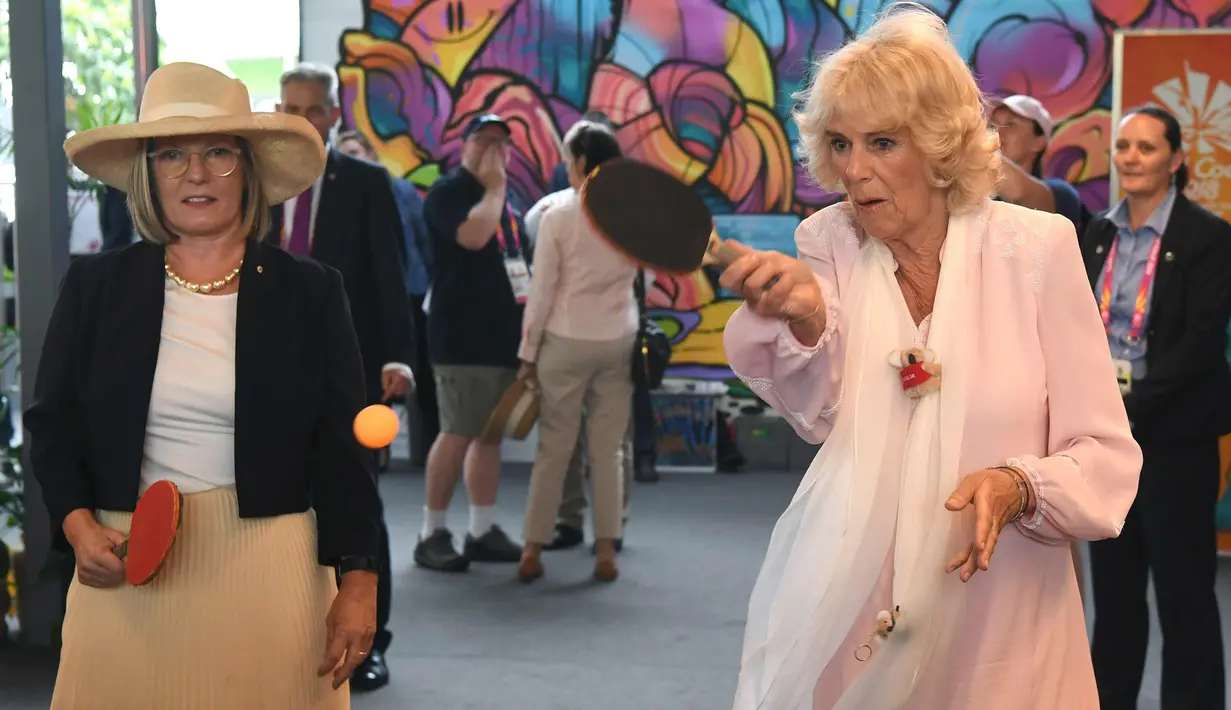Istri Pangeran Charles, Camilla Parker memukul bola saat bermain tenis meja dengan Istri PM Australia, Lucy Turnbull selama kunjungannya ke desa atlet Goldwe Common Games 2018 di Gold Coast (5/4). (AFP Photo/Pool/William West)