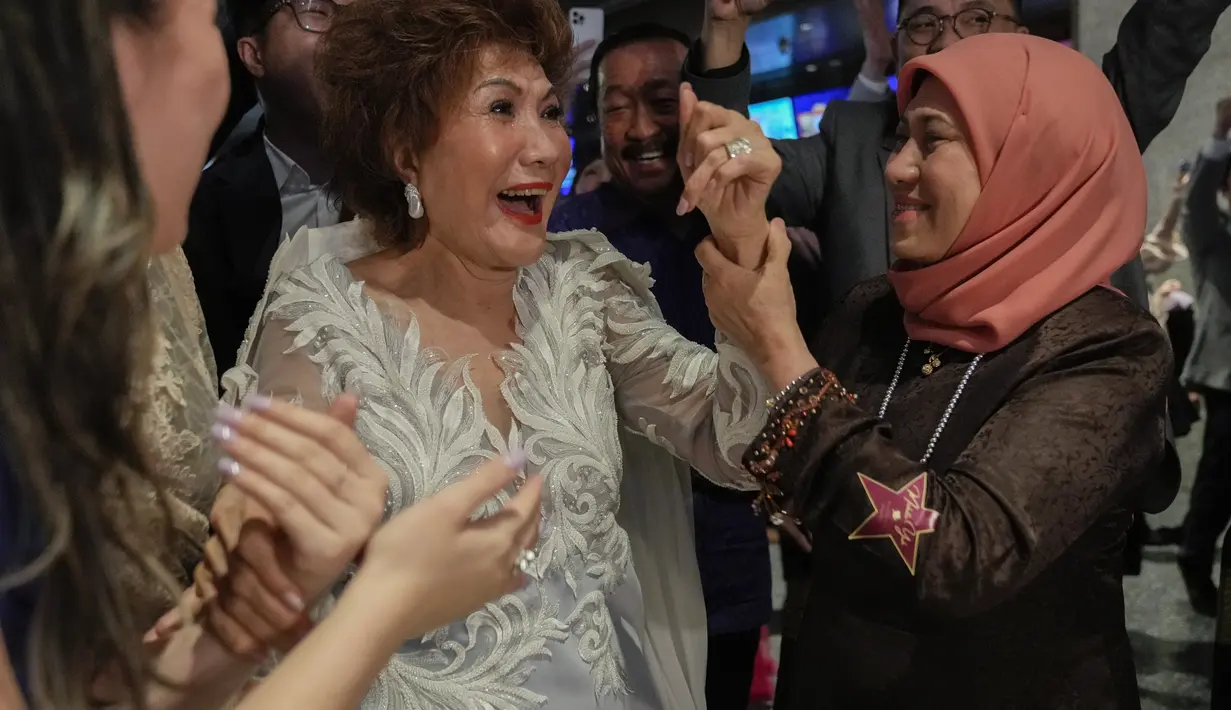 Kegembiraan Janet Yeoh (kanan), ibu dari Michelle Yeoh, setelah putrinya dinobatkan sebegap pemenang kategori aktris terbaik (Actress in Leading Role) selama Academy Awards ke-95 di Los Angeles, yang terlihat dalam acara tayangan langsung di sebuah bioskop di Kuala Lumpur, Malaysia, Senin (13/3/2023). Kemenangan bersejarah ini menandakan aktris Asia pertama yang meraih penghargaan Piala Oscar untuk aktris terbaik di Academy Awards. (AP Photo/Vincent Thian)