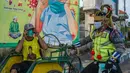 Petugas kepolisian berpakaian superhero memberikan masker kepada warga di jalan kawasan Pasuruan, Jawa Timur, Kamis (9/4/2020). Hal tersebut bertujuan untuk mengantisipasi penyebaran Virus Corona (COVID-19). (JUNI KRISWANTO / AFP)