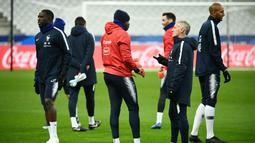Pelatih Prancis, Didier Deschamps, berbincang dengan Steve Mandanda saat sesi latihan di Stade De France, Paris, Minggu (19/11/2018). Prancis akan mejalani laga persahabatan melawan Uruguay. (AFP/Franck Fife)