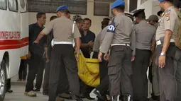 Kantong jenzah dibawa masuk petugas kepolisian ke ruang jenazah di RS Bhayangkara Palu, Sulawesi Tengah, Selasa (17/7). Dua jenazah diduga teroris Santoso alias Abu Warda dan Muhtar yang tewas dalam baku tembak itu akan diidentifikasi. (OLAGONDRONK/AFP)