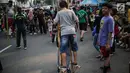 Anak-anak bermain permainan tradisional egrang ditemani sejumlah mahasiswa dari Penggerak Olahraga saat car free day (CFD) di kawasan Bundaran HI, Jakarta, Minggu (14/7/2019). Kegiatan yang rutin digelar ini bertujuan mengajak masyarakat DKI Jakarta aktif berolahraga. (Liputan6.com/Faizal Fanani)