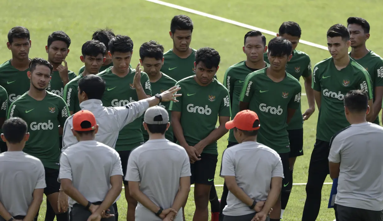 Para pemain Timnas Indonesia U-22 mendengarkan instruksi dari Indra Sjafri saat latihan di Stadion Madya, Jakarta, Kamis (17/1). Latihan ini merupakan persiapan jelang Piala AFF U-22. (Bola.com/Yoppy Renato)