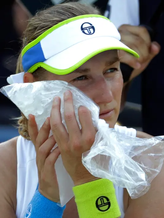 Petenis Rusia, Ekaterina Makarova menaruh es di wajahnya karena kepanasan saat istirahat bertanding melawan Julia Goerges asal Jerman di putaran kedua AS Terbuka, New York, Rabu (29/8). (AP Photo/Seth Wenig)