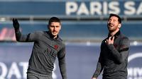 Penyerang PSG Lionel Messi (kanan) tertawa bersama Marco Verratti selama sesi latihan di tempat latihan klub Camp des Loges di Saint-Germain-en-Laye pada 14 Februari 2022. PSG akan menjamu Real Madrid pada leg pertama babak 16 besar Liga Champions, Rabu 16 Februari 2022. (FRANCK FIFE/AFP)