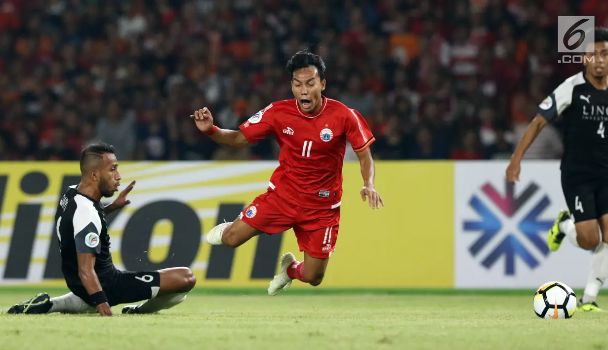 Gelandang Persija, Novri Setiawan melompat menghindari tekel pemain Home United pada laga kedua Semifinal Zona Asia Tenggara Piala AFC 2018 di Stadion GBK, Jakarta, Selasa (15/5). Persija kalah 1-3 dan tersingkir. (Liputan6.com/Helmi Fithriansyah)