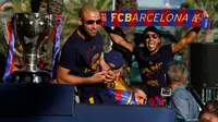 Pemain Barcelona, Javier Mascherano (kiri) dan Neymar, mengikuti pawai dengan bus mengililingi kota Barcelona untuk merayakan gelar La Liga ke-24 bagi Barcelona, (15/5/2016). (AFP/Pau Barrena)
