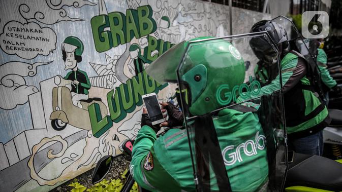 Driver Grab Bike mengenakan Grab Protect pelindung yang membatasi antara pengemudi dan penumpang saat diluncurkan di Jakarta, Selasa (9/6/2020). (Liputan6.com/Faizal Fanani)