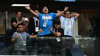 Legenda sepak bola dunia, Diego Maradona (tengah) merayakan gol yang dicetak Lionel Messi saat melawan Nigeria pada laga grup D Piala Dunia 2018 di Saint Petersburg Stadium, Saint Petersburg, (26/6/2018). Argentina menang 2-1. (AFP/Giuseppe Cacace)