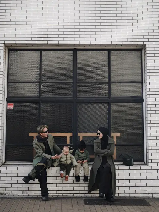 Potret gaya OOTD Rey Mbayang dengan istri dan anak tercinta ini pun tampak kasual namun stylish. Keluarga selebriti ini terlihat memadukan busana serba hitam dengan long coat berwarna hijau army. (Liputan6.com/IG/@rey_mbayang)