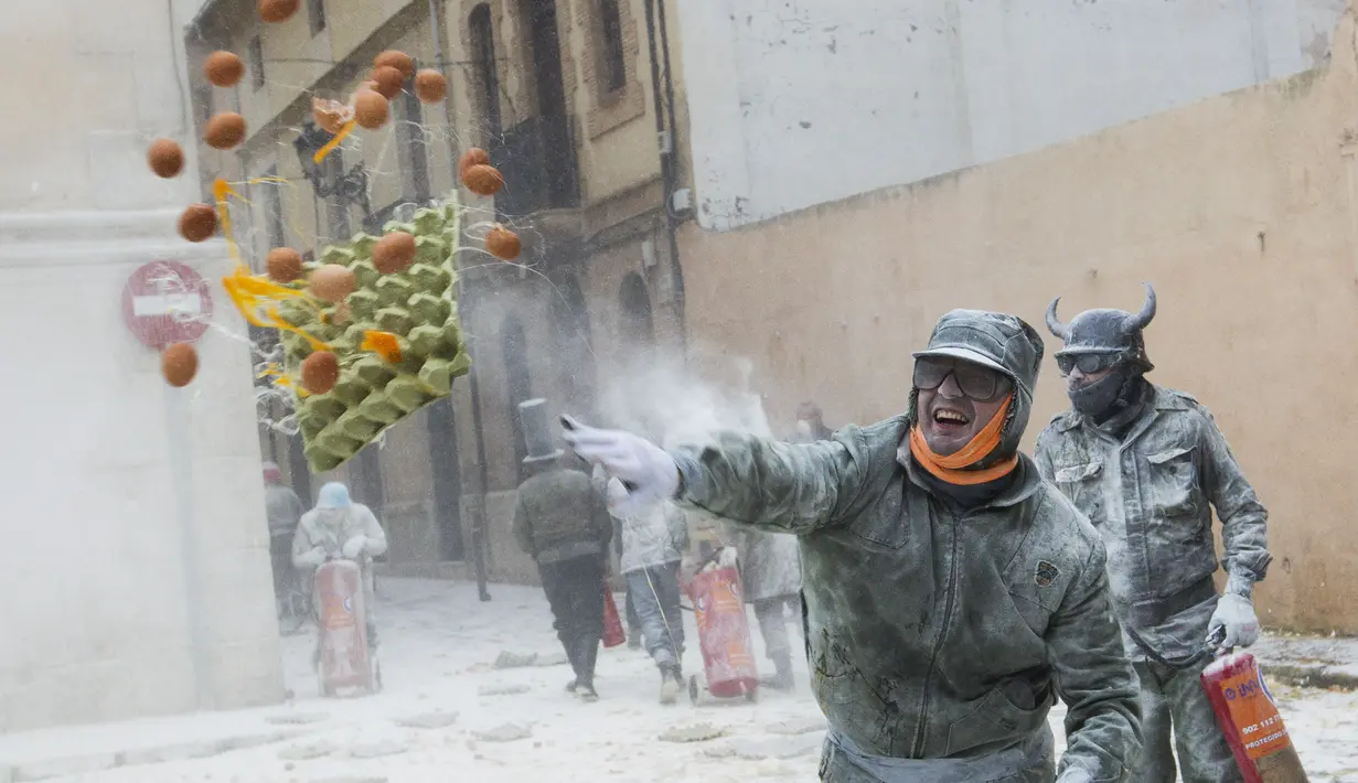 Keseruan peserta dalam Festival Els Enfarinats di Kota Ibi, Spanyol, Senin (28/12). Dalam festival ini para peserta akan dibagi menjadi dua kelompok untuk bertempur dengan saling melempar tepung dan telur. (AFP PHOTO / Jamie Reina)