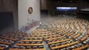 Pekerja dari Asosiasi Pengendalian Hama Korea menyemprotkan disinfektan sebagai  tindakan pencegahan terhadap penyebaran virus corona COVID-19, di Majelis Nasional Seoul (25/2/2020). (AFP/Yonhap)