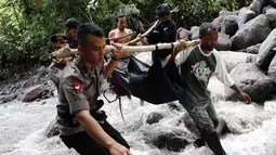 Petugas dan warga saat mengevakuasi jenazah korban banjir bandang di kawasan Air Terjun Dua Warna, Deli Serdang, Sumatera Utara, Senin (16/5). Saat banjir bandang terjadi sekitar 80 orang yang berkemah di tempat tersebut. (ALBERT DAMANIK / AFP)