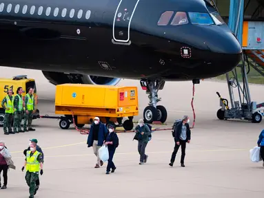 Para penumpang yang dievakuasi dari kapal pesiar MV Hondius, diduga terjangkit hantavirus, tiba di bandara Eindhoven, Belanda, Minggu 10 Mei 2026. Puluhan penumpang dan awak kapal pesiar MV Hondius telah dievakuasi dari Tenerife, Kepulauan Canary, Spanyol. (AP Photo/Peter Dejong)