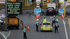 Polisi dan petugas Dishub memberi arahan kepada pengendara mobil di depan Gerbang Tol Bekasi Barat 1, Bekasi, Jawa Barat, Senin (12/3). Peraturan ganjil genap ini berlaku mulai hari ini, Senin (12/3) pukul 06.00-09.00. (Liputan6.com/Arya Manggala)